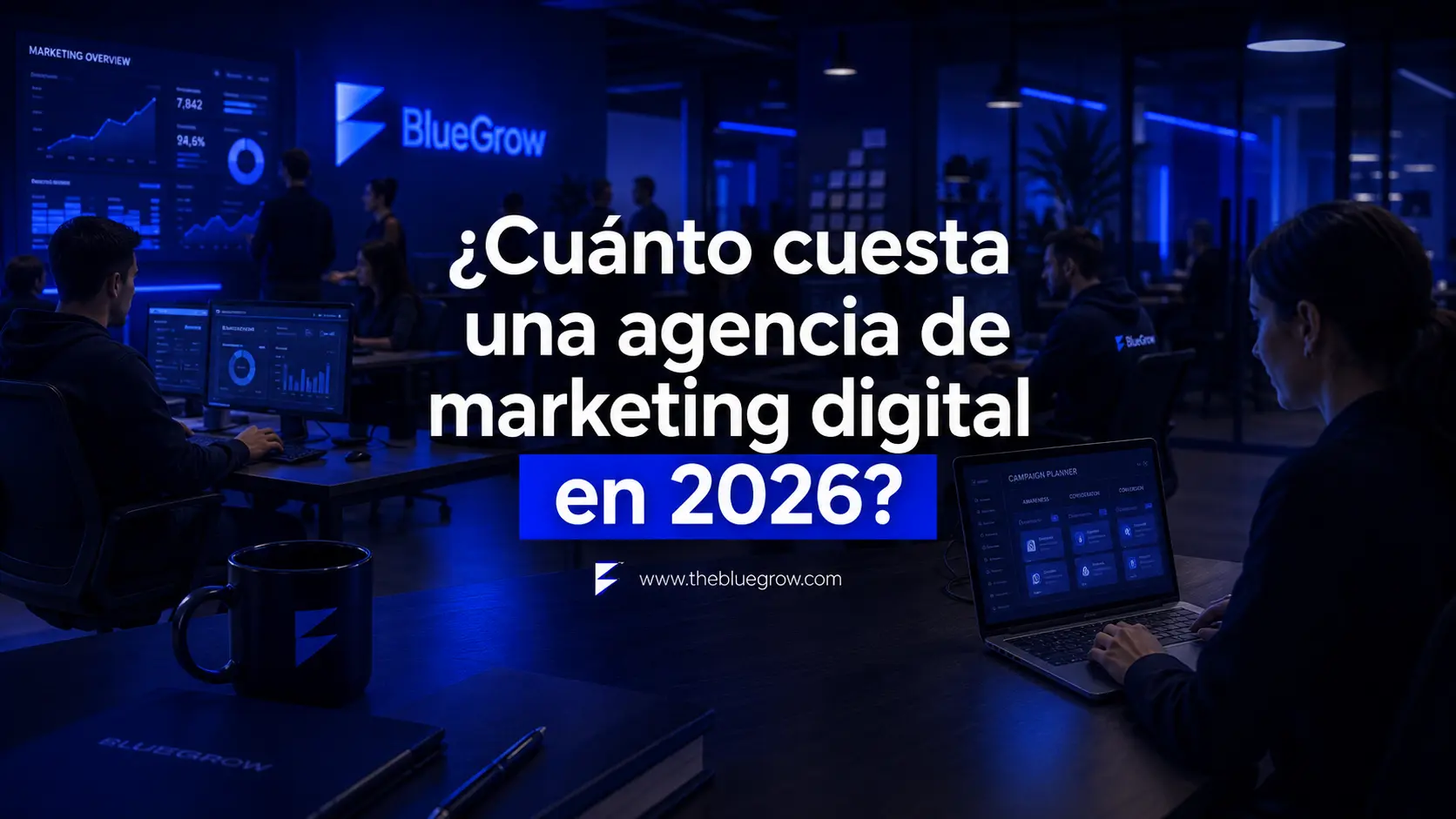 Equipo en una agencia de marketing digital con portátiles y dashboards de analítica sobre su coste en 2026